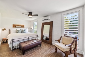 This bedroom has a king bed and ceiling fan.
