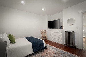 Stream your favorite shows from bed in this calm retreat with hardwood floors below.