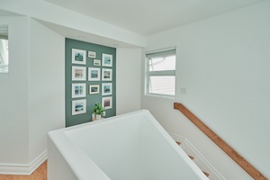 Features a calming green accent wall with curated artwork, creating a peaceful retreat for restful nights.