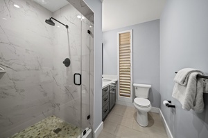 Experience a clean, contemporary bathroom with a walk-in shower and streamlined design.