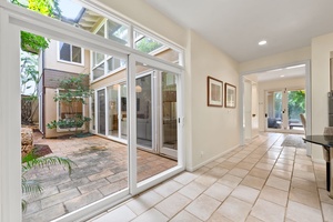 Step into your bright, open living space where floor-to-ceiling windows frame your private courtyard oasis.