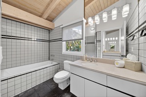 Refresh in the bright ensuite bathroom featuring double sinks and classic tile finishes.
