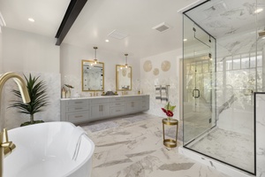 Marble-detailed bathroom with dual vanities and natural light for a serene start to every day.
