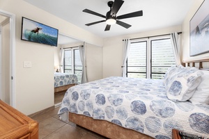 Spacious primary suite with flat-screen TV, cooling cross-breeze windows, and tranquil decor.