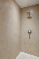 Refresh in your private walk-in shower with modern fixtures and elegant tile design.