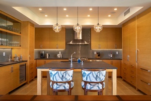 Chefs Kitchen with wolf oven and gas cooktop, Sub-Zero refrigerator, Sub-Zero under-counter wine cooler, and a bar with sink and Sub-Zero ice maker.