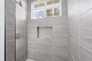Walk-in shower with tile surround and built-in niche—designed with spa-like simplicity.