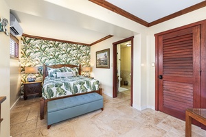 Another view of the island-style bedroom, featuring en-suite access and cool tile flooring.