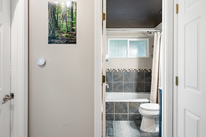 Alternate view of the charming bathroom with tiled floors and a shower-tub combination.
