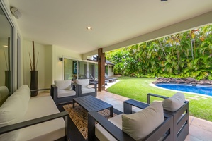 Covered lanai lounge with plush seating, perfect for evening cocktails.