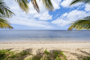 Stunning beachfront with wide-open blue skies and calm, inviting ocean waves — a perfect place to swim or simply savor the view.