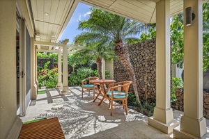 Exterior kitchen cafe table seating surrounded by tropical foliage.