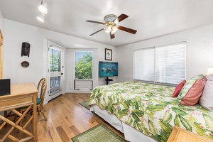 Relax in your bright bedroom with tropical bedding, ceiling fan, and charming details creating perfect island vibes.