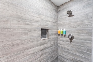 Stylish walk-in shower with rainfall head and modern tile—refreshing after a beach day.