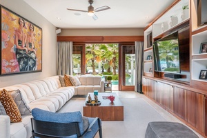 This living space features a cozy sofa, large TV and direct access to the outdoors.