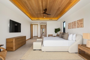 Unwind in your spacious bedroom featuring warm wood accents, crisp linens, and modern amenities for the perfect tropical retreat.