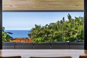 Sweeping ocean views framed by vibrant tropical plants and a modern patio design.