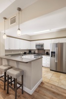 Your fully equipped kitchen awaits with modern appliances, granite countertops, and breakfast bar seating for casual dining.