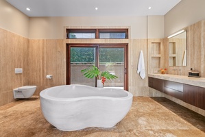 A large soaking tub awaits in the spa-like ensuite bath after a day of exploration.