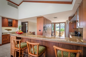 Bar seating at the kitchen counter with the wet bar toward the left.