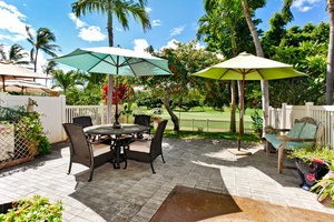 A tranquil outdoor seating area overlooks the golf course, surrounded by tropical landscaping.