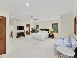 Spacious cottage with plush carpeting, ceiling fan, and cozy seating area perfect for relaxation.