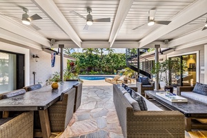Take a seat under the covered lanai with views of the pool and garden.