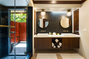 Outdoor-inspired ensuite bath with dual sinks and direct access to the lush private courtyard.