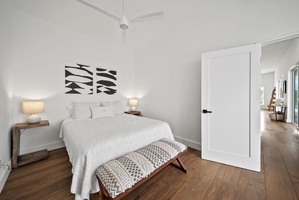 The minimalist-style guest suite upstairs with a cozy queen bed for restful nights.