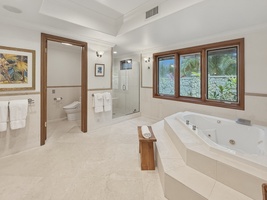 Indulge in your own spa-like sanctuary with a jetted tub and stand alone shower, where tropical garden views create a serene retreat.
