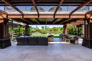 Expansive lanai space with comfortable seating, a dining area, and views of the pool and garden