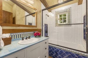 Ensuite bathroom with single vanity and shower/tub combo.