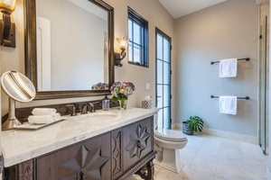 Elegant bathroom featuring a classic vanity, natural light, and tasteful decor.