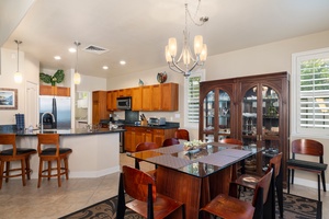 Cook together in this elegant kitchen featuring rich wood cabinetry, granite countertops, and a spacious island perfect for meal prep and casual dining.