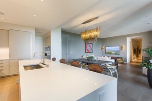 Your sophisticated open-plan space flows seamlessly from kitchen to dining, where elegant lighting and modern design create the perfect atmosphere for memorable meals.