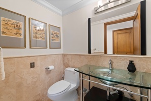 Warm stone finishes and thoughtful details bring a polished, spa-like feel to the bathroom.