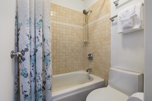 Step into your private bathroom featuring a relaxing tub-shower combo with fresh towels and all essentials ready for your stay.