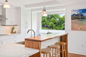 Modern kitchen with bar seating, ideal for vacation breakfasts and gatherings.