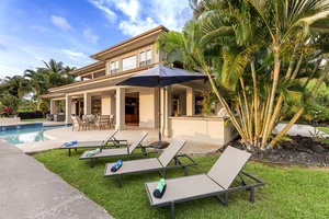 Expansive backyard with a sparkling pool, shaded seating, and tropical ambiance.