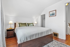 The upstairs king bedroom offers plush comfort, natural light, and an inviting space to recharge.