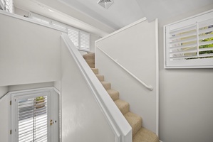 A bright and airy stairway leading to the serene guest bedrooms of this Hawaii vacation home.