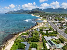 Bird's eye view showcasing pristine beaches, turquoise waters, and dramatic mountain backdrop in this tropical coastal paradise.