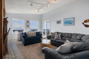 The West-facing living room has a cozy space to unwind with comfortable seating and a spectacular view of the water.