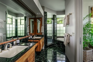 Elegant bathroom featuring marble finishes, dual sinks, and a jetted tub