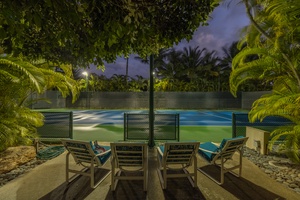 Shaded lounge chairs by the tennis court for spectators and post-game rest.