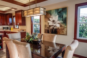 Host intimate dinners at the formal dining table, enhanced by contemporary lighting and tropical artwork.