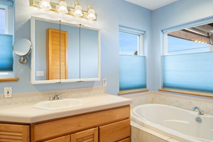 Unwind in your serene bathroom with soaking tub, elegant vanity, and soft blue tones creating a spa-like retreat.