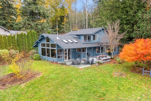 Lush lawn and mature trees surround this inviting retreat—ideal for outdoor games, lounging, or soaking up the scenery.