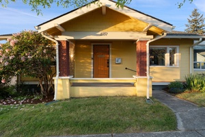 Step onto the inviting front porch framed by classic columns and mature landscaping.
