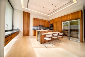 Kitchen featuring sleek wooden cabinetry, high-end appliances, and a spacious island with modern seating.